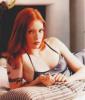 Alicia Witt lying on the bed