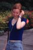 Alicia Witt outside in blue top and jeans